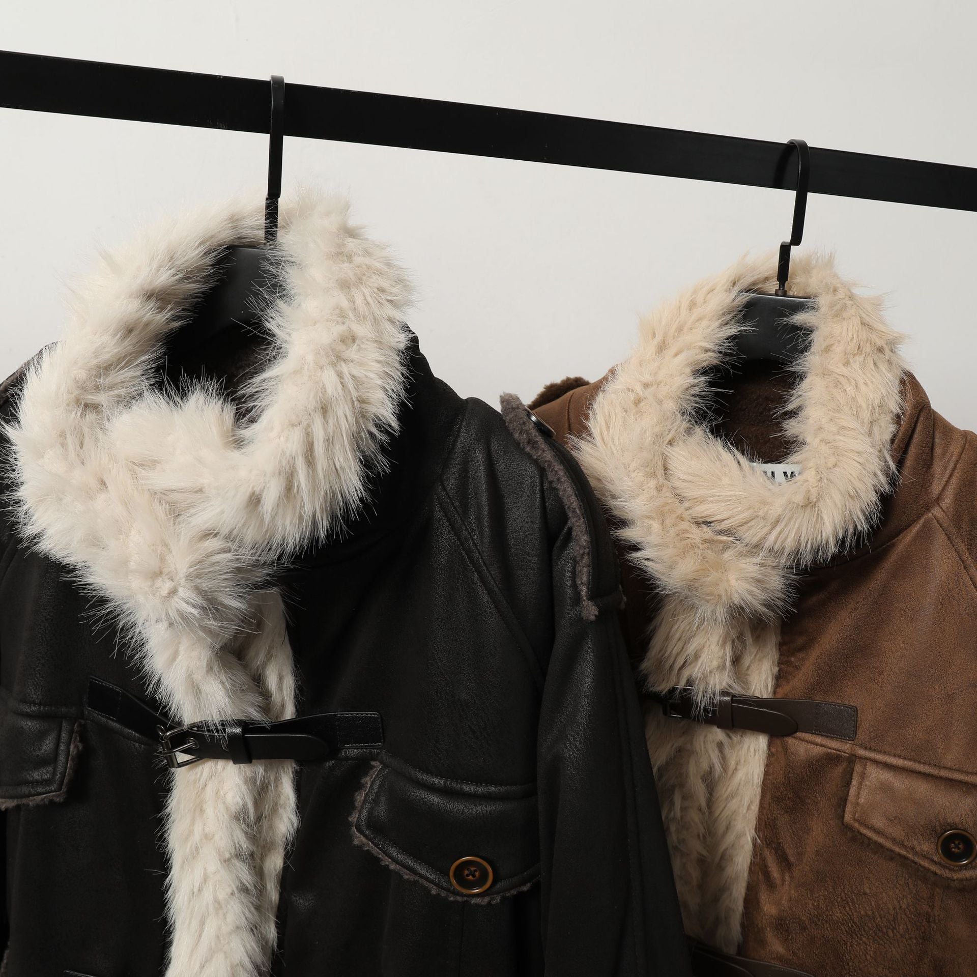 Close-up of black and brown Leather Coats with faux fur collars and wool cotton blend texture, highlighting winter fashion details.