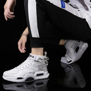 White Air Force One sneakers with high-top design and bold text details, worn with black and white joggers. Stylish non-slip footwear for men.